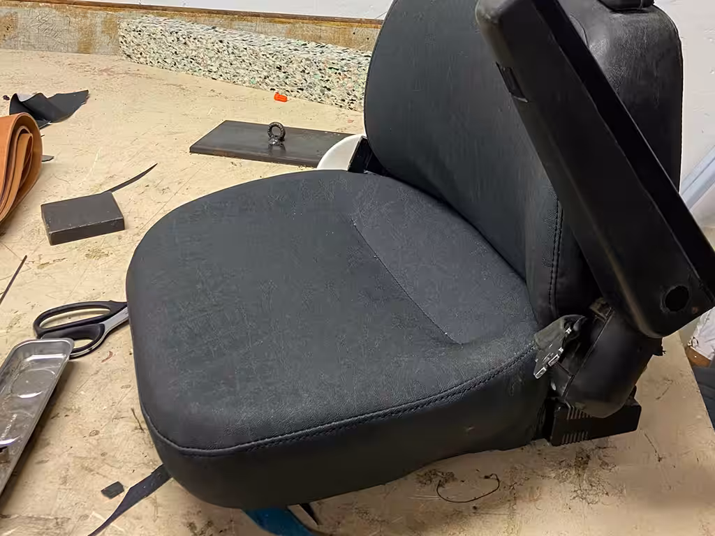 Autositz nach dem Neubezug in schwarzem Leder – Autosattlerei Wick Wil